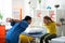 Attentive caring long-haired doctor correcting posture of little girl