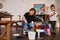 Attentive caucasian woman sitting at the floor near the buckets with paint