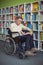 Attentive disabled school teacher reading book in library