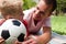 Attentive father and his son holding a soccer ball