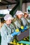 Attentive female employees in uniform sorting fresh apples on producing grading line