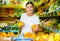 Attentive girl buyer chooses fresh oranges