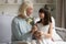 Attentive little girl greeting excited grandparent presenting flowers