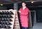 Attentive man wearing uniform working with bottle storage racks