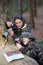 Attentive mother and son taking pictures in autumn forest