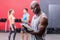 Attentive muscular trainer writing on clipboard