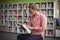 Attentive school teacher reading book in library