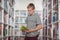 Attentive schoolboy reading book in library