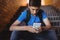 Attentive schoolboy using mobile phone on staircase