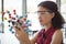 Attentive schoolgirl experimenting molecule model in laboratory