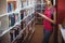 Attentive schoolgirl using digital tablet in library