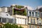 Attic balcony with many green plants on the top floor of a building in the historical center of Paris