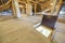 Attic of a building with wooden beams of a roof structure and a fire exit door in floor