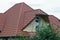 The attic of a private house with a brown tiled roof and an open metal balcony