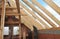 Attic roof beams against blue sky. Constructing rooftop frame from wooden beams. Attic under construction indoor
