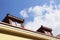 Attic windows in roof on blue sky and clouds background