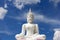 The attitude of meditation white buddha against blue sky.