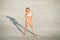 Attractive adult girl enjoys beach walking in the sand