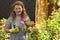 Attractive adult woman gardener grows flowers roses