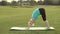 Attractive adult woman practicing yoga in park