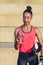 Attractive african american young female boxer dressing sports clothes and holding boxing gloves and a plastic bottle of mineral