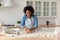 Attractive African housewife kneading dough, prepare pastries in kitchen