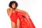 Attractive african lady in a red sexy swimsuit holds a strawberry swimming mattress on a white studio background