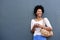 Attractive african woman smiling with mobile phone and bag