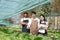 Attractive agriculturists harvesting green oak and lettuce together at green house farm. Asian farmers work in