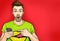 Attractive amazed young man pointing finger on mobile phone in comic style. Pop art surprised guy