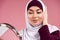 Attractive Arab woman in hijab looks in mirror