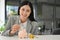 Attractive Asian businesswoman insert coins in a pin piggy bank on the table. saving money