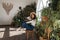 Attractive Asian girl sitting in chair relaxing in garden with many indoor green plants.