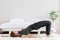 Attractive Asian woman practice yoga Half bridge pose to meditation in bedroom