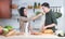 Attractive Asian young sweet couple cooking together in home kitchen. Beautiful woman smiling feeding her handsome man with bread