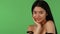 Attractive Asian young woman posing dreamily on green chromakey