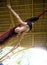 Attractive and athletic aerialist woman hanging from silk fabric doing aerial dancing workout training happy at beautiful hut in