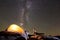 Attractive athletic girl doing push-up exercises on big boulder on dark starry sky