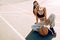 Attractive athletic young woman outdoor posing sitting on basketball court holding basketball