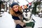 Attractive authentic caucasian woman hugs funny malamute dog wearing santa dear christmas antlers. Curly smiling female