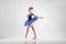 Attractive ballerina with bun collected hair wearing blue dress