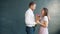 Attractive bearded guy giving bunch of flowers to surprised girl kissing smiling