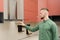 Attractive bearded man in a green shirt turns on a fume hood in a modern kitchen