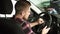 Attractive bearded man smiling to the camera over his shoulder sitting in a new car