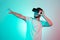 Attractive bearded man trying VR headset and poniting. Young man exploring another world with virtual reality goggles on