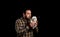 Attractive bearded man in a yellow plaid shirt with a stuffed puppy posing isolated on black background