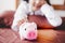 Attractive beautiful woman is putting a coin to the piggy bank. Charming beautiful asian woman is always economizing and saving