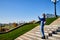 Attractive beautiful young girl holding cell phone in autumn park and making selfie. Traveller on the steps