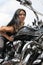 Attractive biker woman sitting on her motorcycle