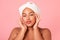 Attractive black body positive woman with smooth skin touching face and looking at camera, enjoying self-care routine
